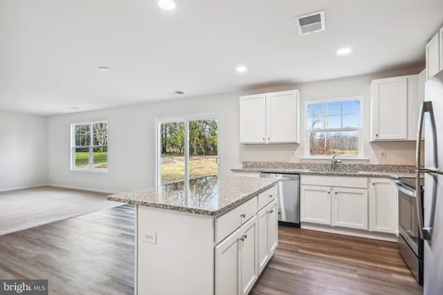 a kitchen with granite countertop sink stove and cabinets