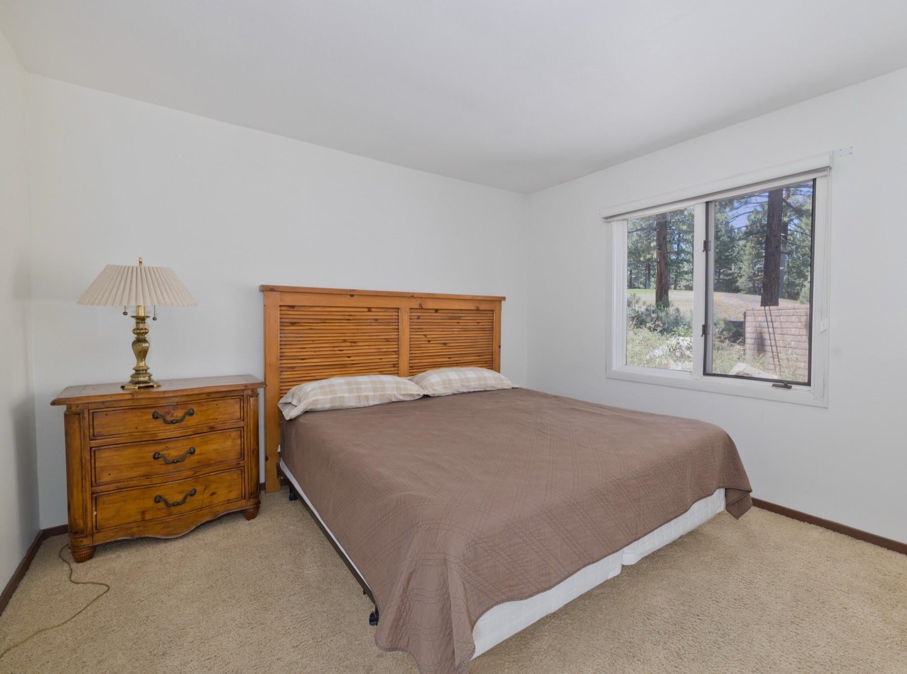 3392 Chateau Road, Unit 29 Mammoth Lakes, CA 93546 - Photo 19 of 30 Bedroom featuring light-toned carpeting, white walls, and a large window overlooking natural scenery