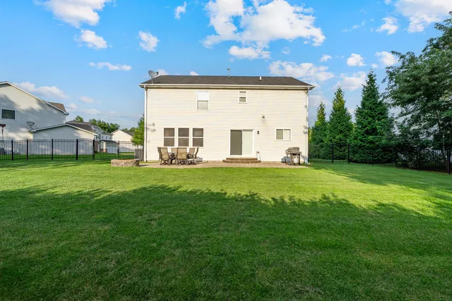 a view of a house with a big yard and large tree