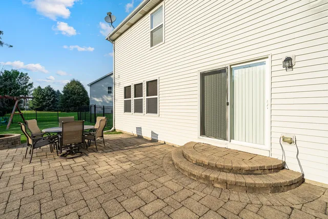 a backyard of a house with a table and chairs