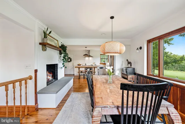 a view of a dining room and hall with furniture window and wooden floor
