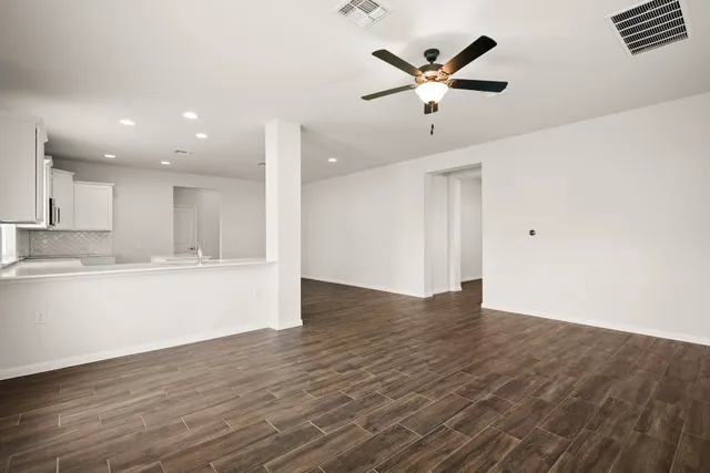 a view of an empty room with cabinet and wooden floor
