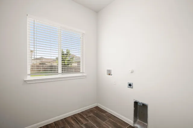 a view of small space with wooden floor and a window