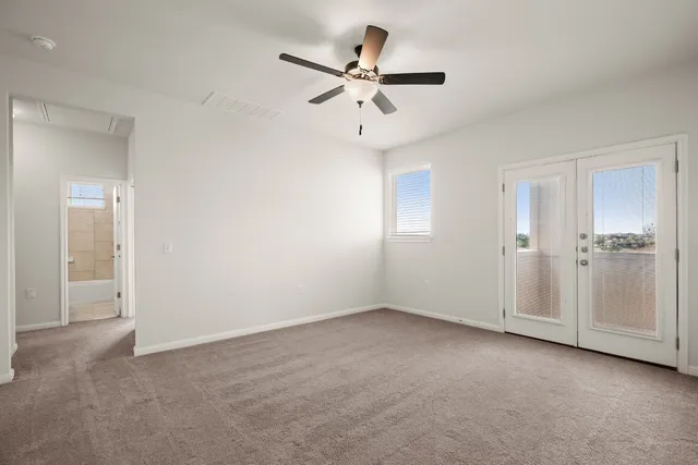 a view of an empty room with a ceiling fan