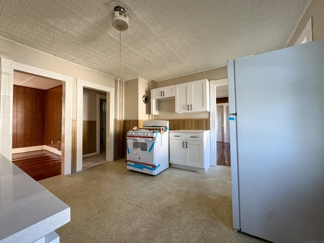 a kitchen with stainless steel appliances granite countertop a refrigerator a stove and a sink
