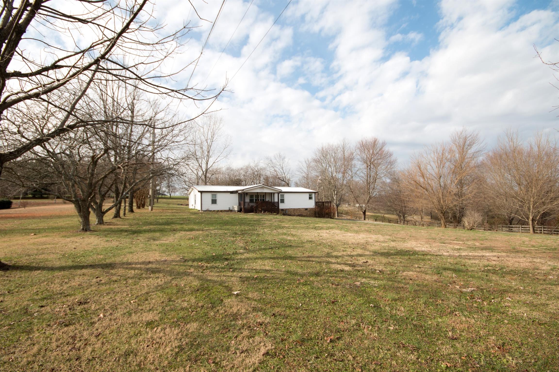 149 Mitchell Road Portland, TN 37148 - Photo 3 of 29 a tall yellow house with a big yard next to a road