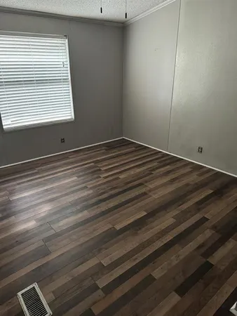a view of a room with wooden floor and window