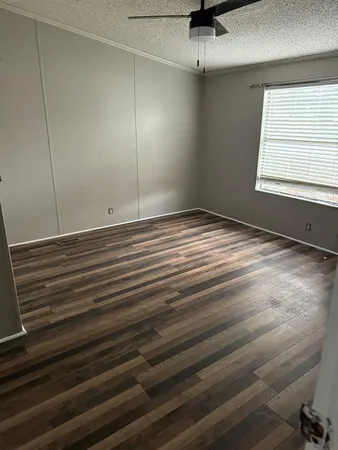 a view of a room with wooden floor and windows