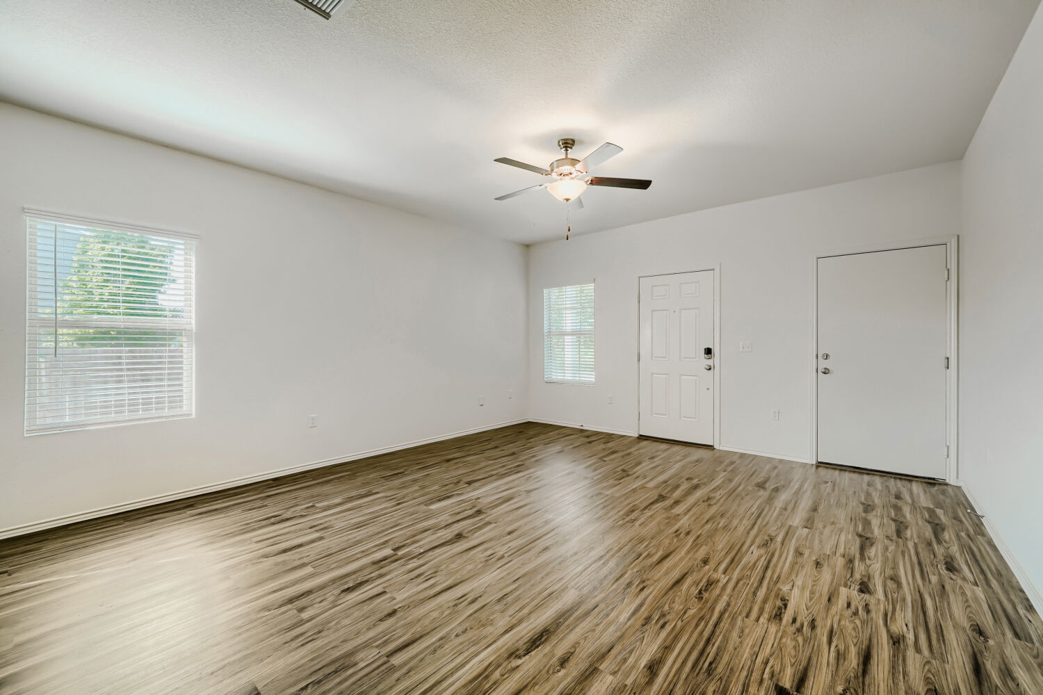 7001 Tonka Lane Austin, TX 78744 - Photo 5 of 30 a view of an empty room with a window and wooden floor
