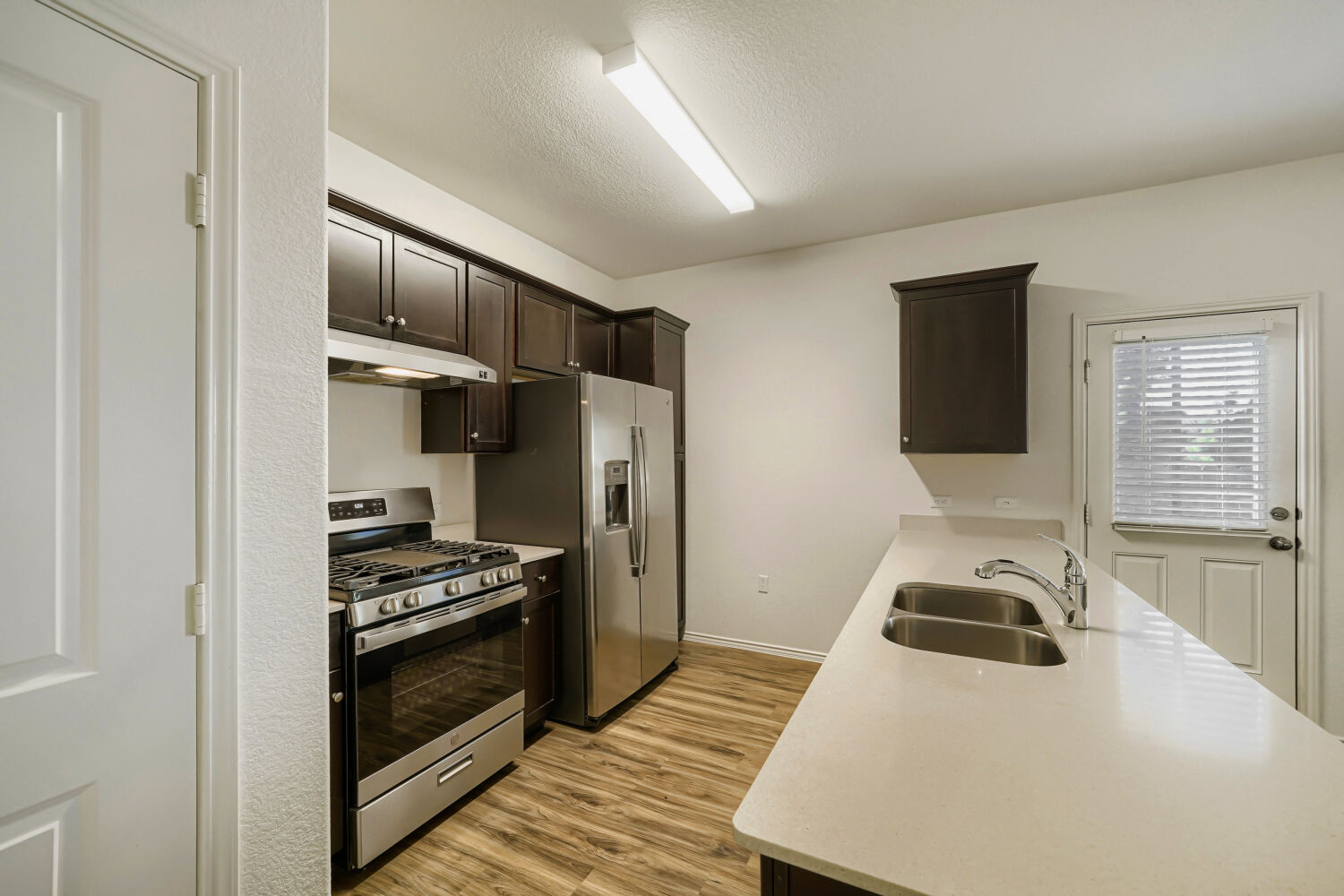 7001 Tonka Lane Austin, TX 78744 - Photo 9 of 30 a kitchen with a refrigerator stove and wooden floor