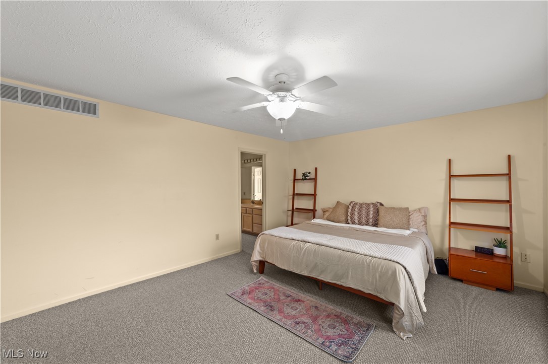 4422 Brooks Road Cleveland, OH 44105 - Photo 19 of 46 Carpeted primary bedroom featuring ceiling fan, a textured ceiling, and ensuite bathroom