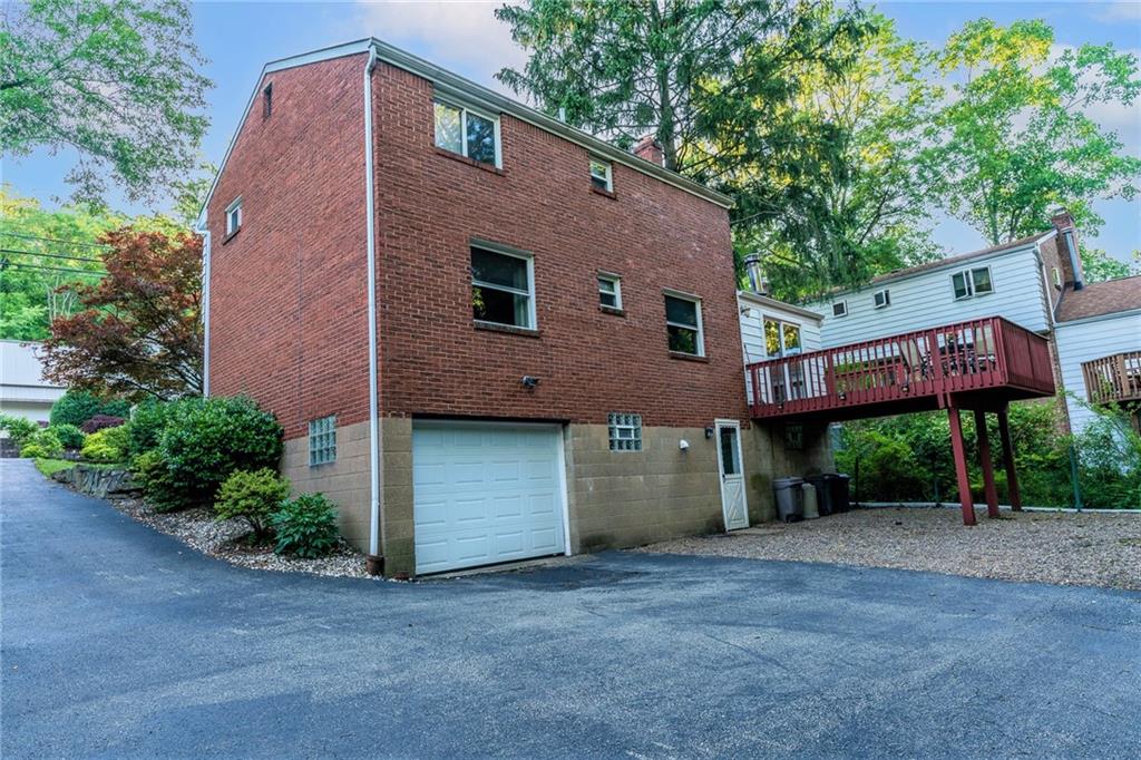 586 Filmore Road Pittsburgh, PA 15221 - Photo 5 of 25 a front view of a house with a yard and garage