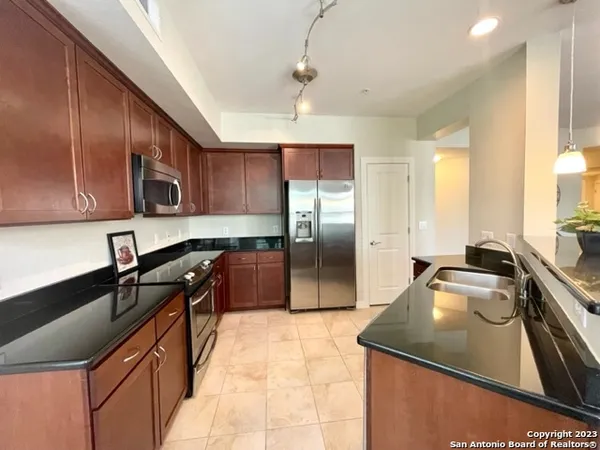 a kitchen with granite countertop a sink stainless steel appliances and cabinets