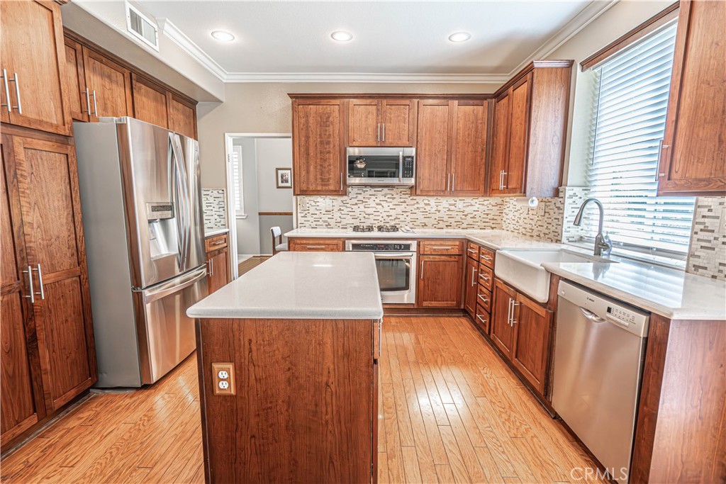28772 Woodside Drive Saugus, CA 91390 - Photo 8 of 23 a kitchen with stainless steel appliances granite countertop a refrigerator a sink dishwasher a stove with wooden cabinets and floor