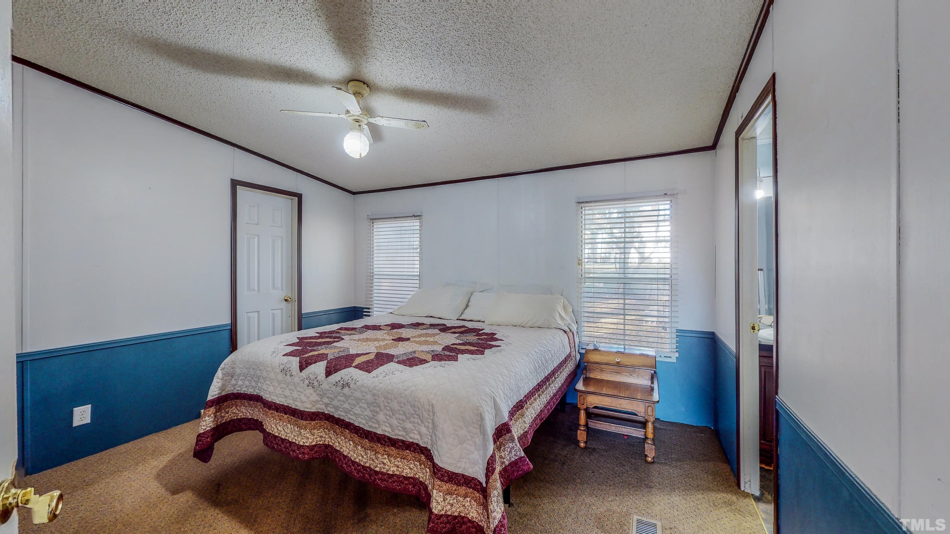 200 David Lane Roxboro, NC 27573 - Photo 14 of 38 a bedroom with a bed and a chandelier