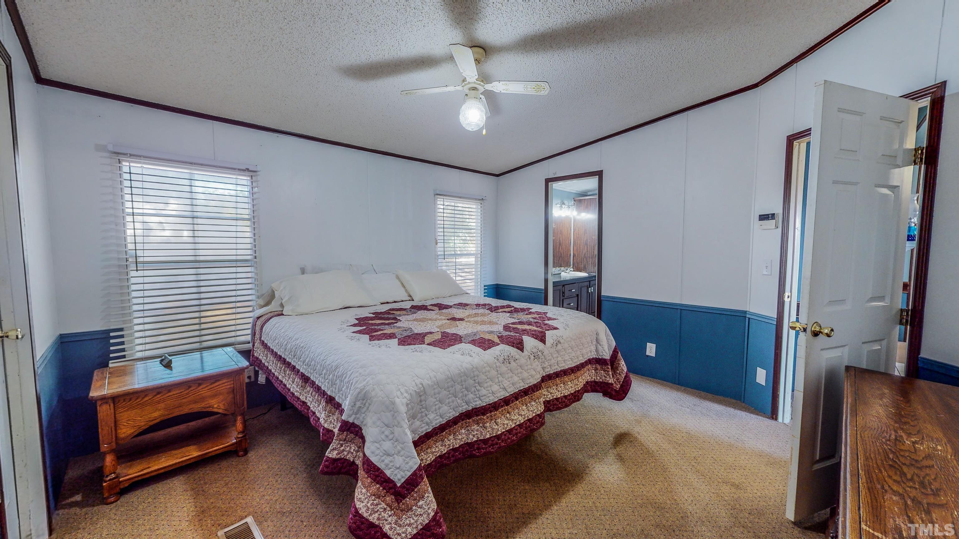 200 David Lane Roxboro, NC 27573 - Photo 15 of 38 a bedroom with a bed and a chandelier