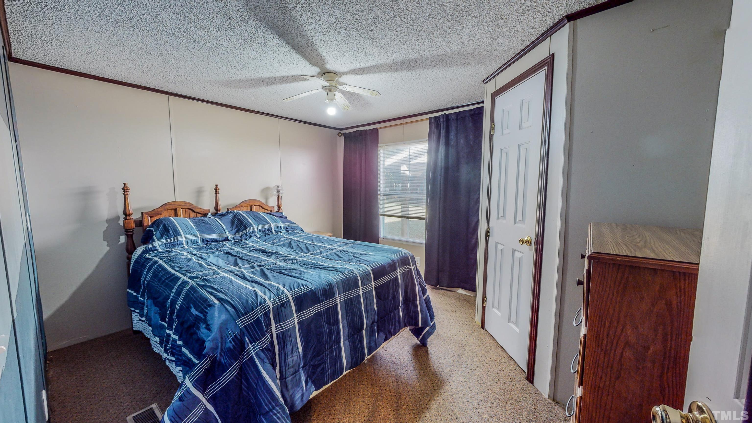 200 David Lane Roxboro, NC 27573 - Photo 24 of 38 a spacious bedroom with a bed and a chandelier