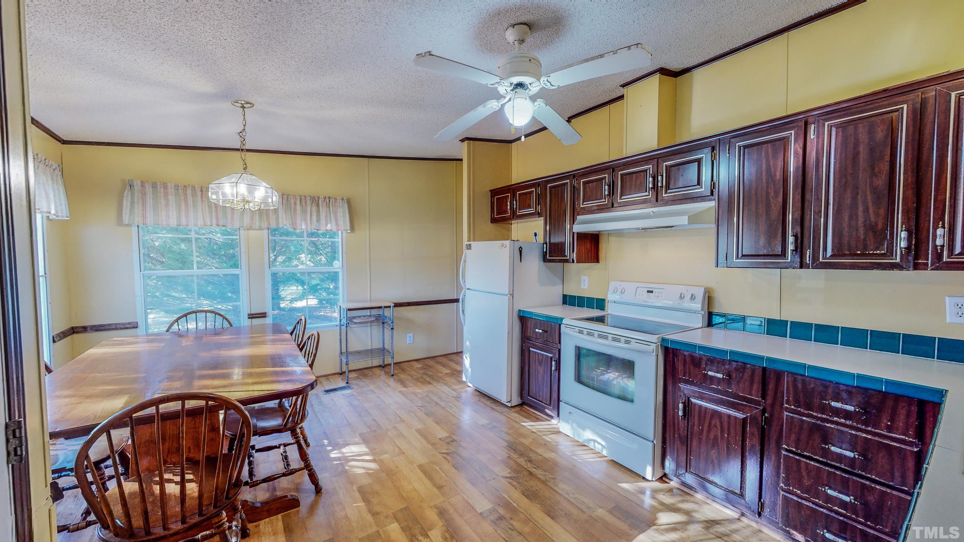 200 David Lane Roxboro, NC 27573 - Photo 3 of 38 a kitchen with stainless steel appliances granite countertop a stove top oven a dining table and chairs with wooden floor