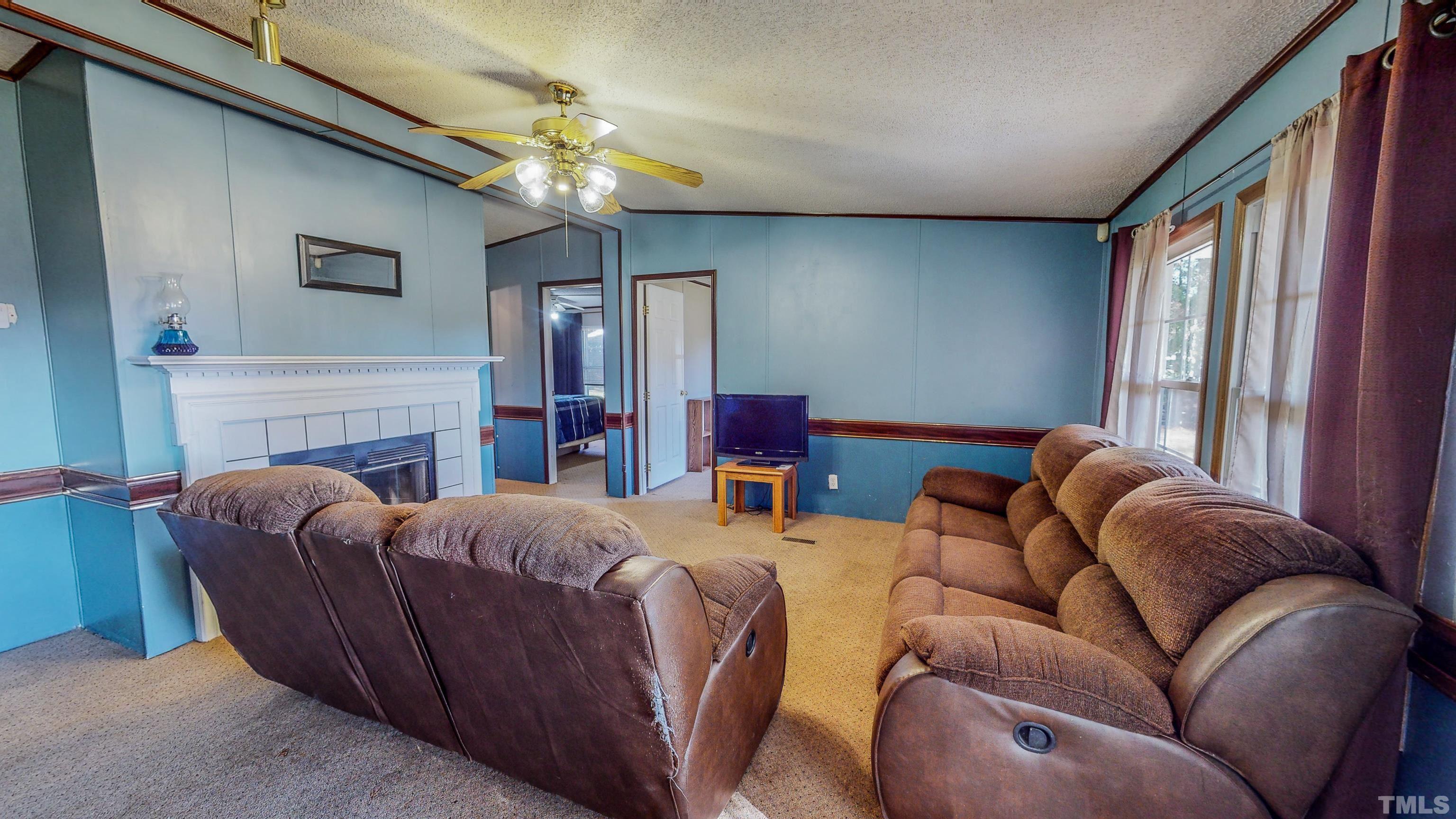200 David Lane Roxboro, NC 27573 - Photo 9 of 38 a living room with furniture a fireplace and a chandelier