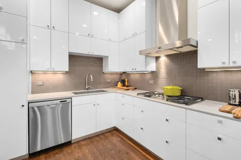 a kitchen with granite countertop white cabinets stainless steel appliances and a sink