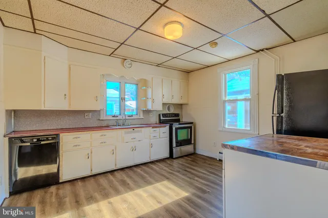 a kitchen with granite countertop cabinets stainless steel appliances a sink and a window