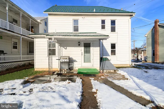 a view of a white house with wooden fence