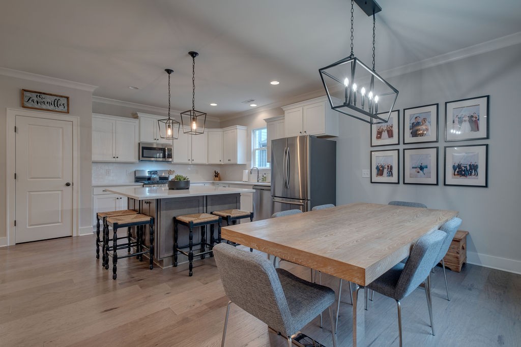 713 Plowson Road Mount Juliet, TN 37122 - Photo 12 of 33 a open kitchen with stainless steel appliances granite countertop a dining table chairs and white cabinets