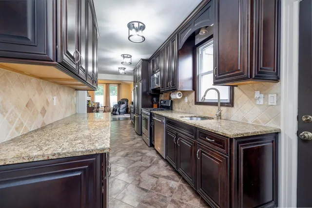a kitchen with stainless steel appliances granite countertop a sink stove and cabinets