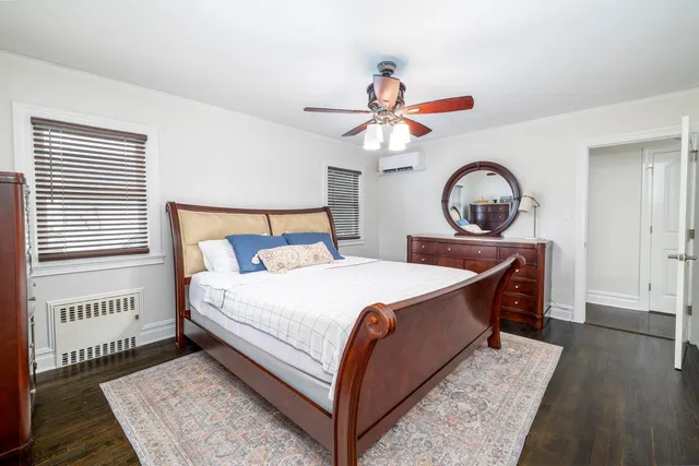 a bedroom with a bed a chandelier and dresser