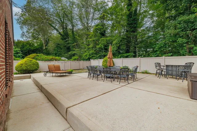 a view of a patio with a table and chairs potted plants with large tree