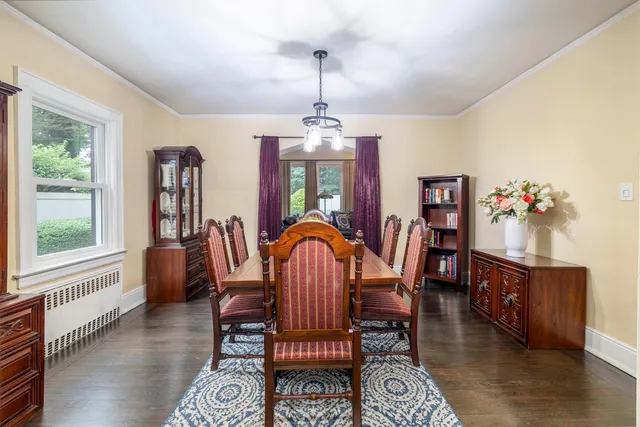 a dining room with furniture a chandelier and wooden floor
