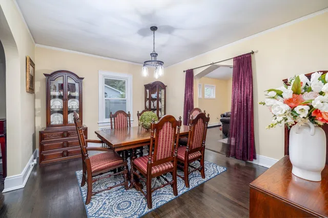 a view of a dining room with furniture a chandelier and wooden floor