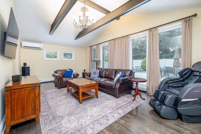 a living room with furniture a large window and a rug