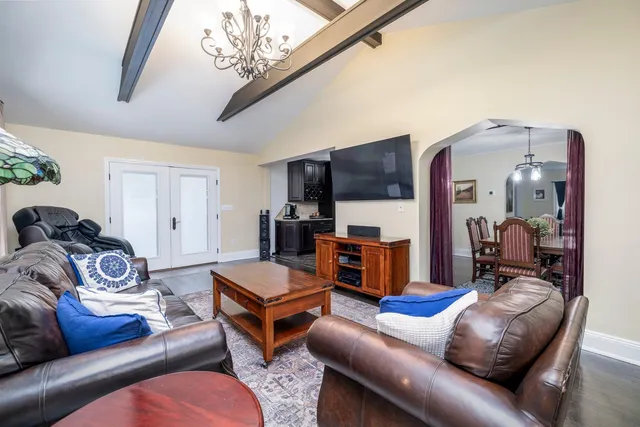 a living room with furniture a flat screen tv and kitchen view