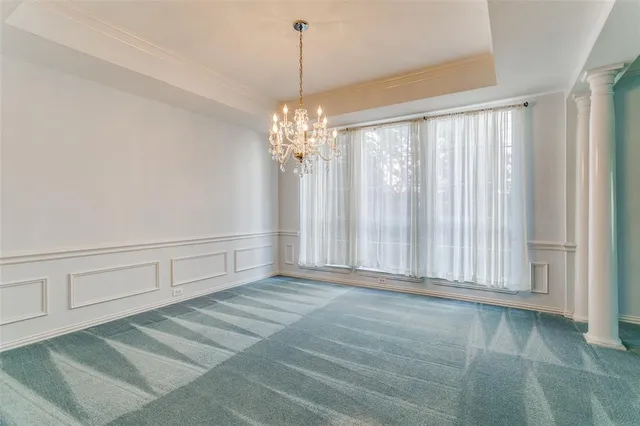 a view of a livingroom with a chandelier fan and windows