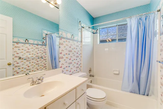 a bathroom with a sink a toilet a mirror a vanity and shower