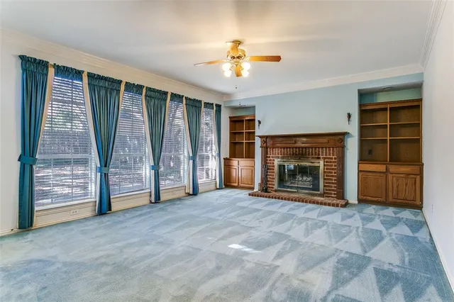 a view of an empty room with a fireplace and a window