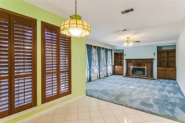 a view of an empty room with a fireplace and a window