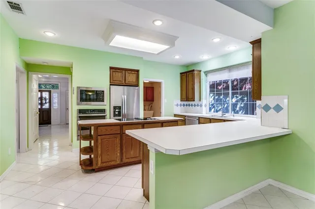 a large kitchen with kitchen island a sink table and chairs