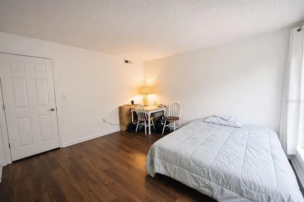 a bedroom with a bed and wooden floor