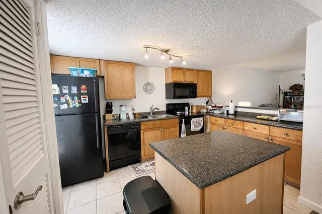 a kitchen with stainless steel appliances granite countertop a refrigerator a stove a sink and a microwave