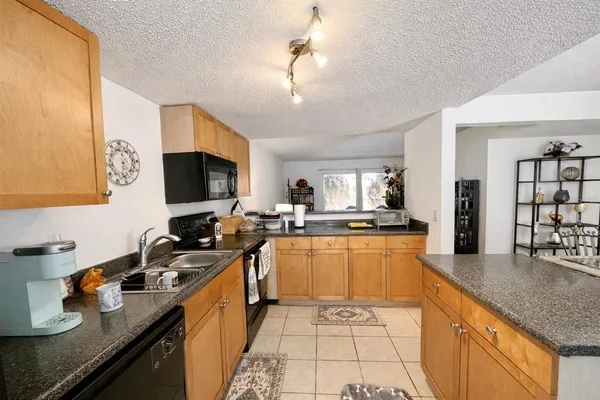 a kitchen with a sink a refrigerator and cabinets