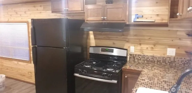 a kitchen with a refrigerator and a stove