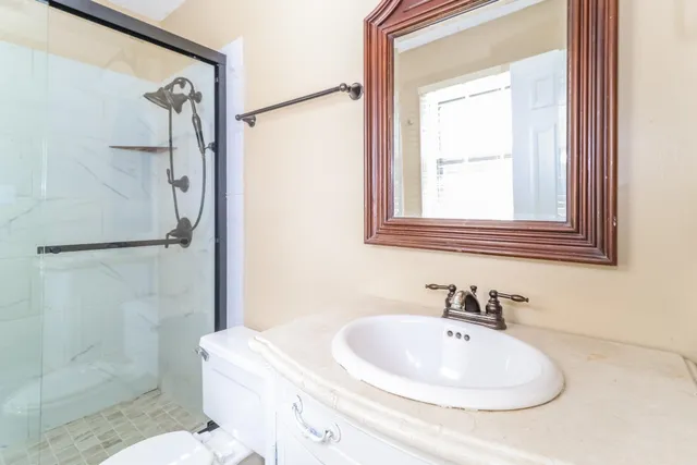 an empty room with windows and chandelier fan