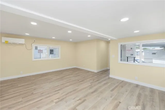 an empty room with wooden floor and window
