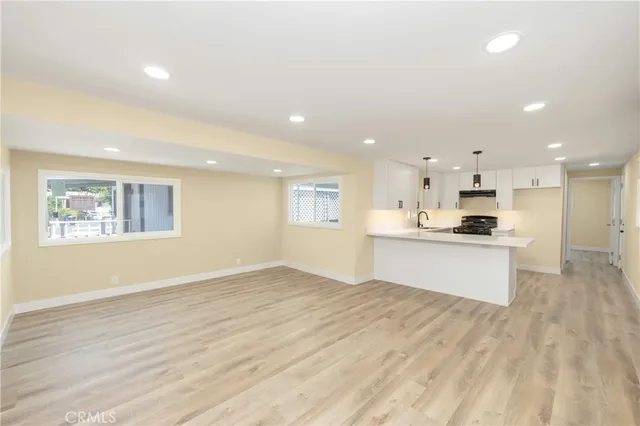 a view of kitchen with kitchen island wooden floor center island and stainless steel appliances