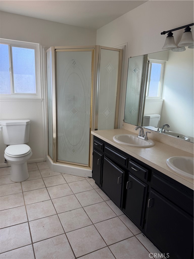15225 Ramona Road Apple Valley, CA 92307 - Photo 3 of 8 a bathroom with a granite countertop sink a toilet and a mirror