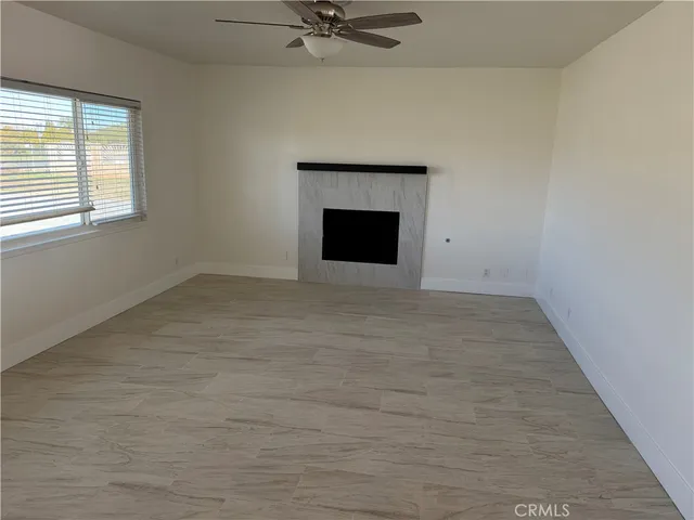a view of an empty room with a fireplace and a window