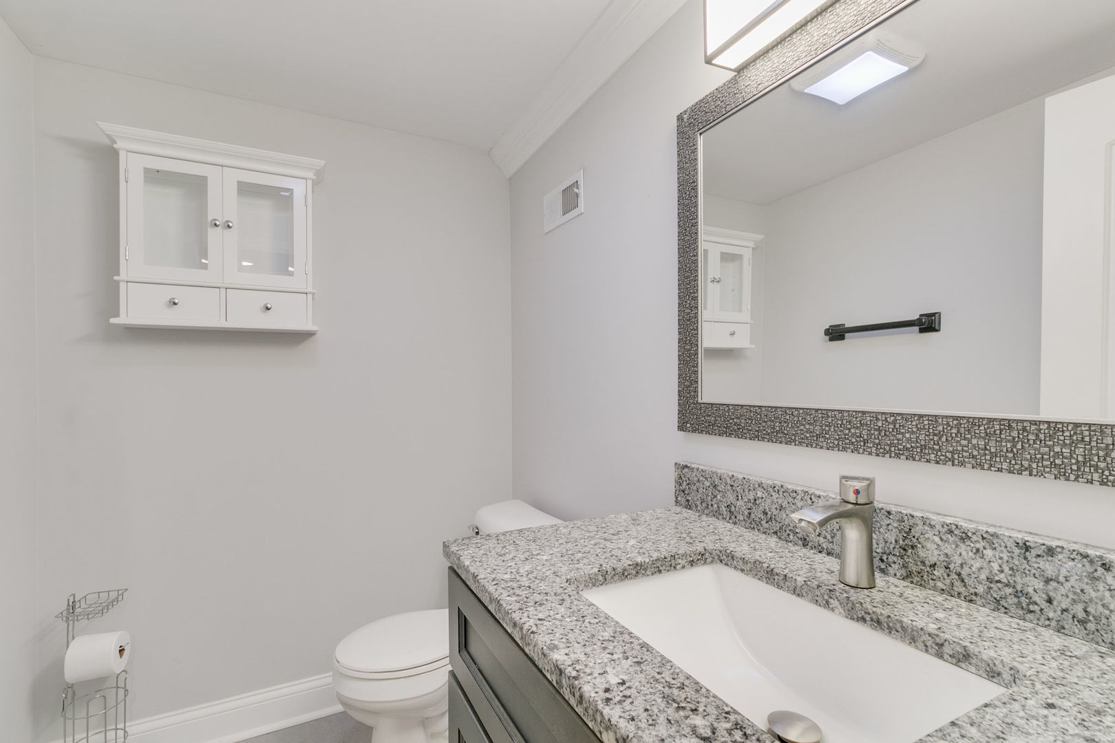 3239 Wesley Avenue Berwyn, IL 60402 - Photo 21 of 29 a bathroom with a granite countertop toilet a sink and a mirror