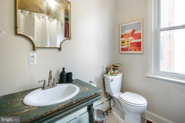 a bathroom with a granite countertop toilet sink and mirror